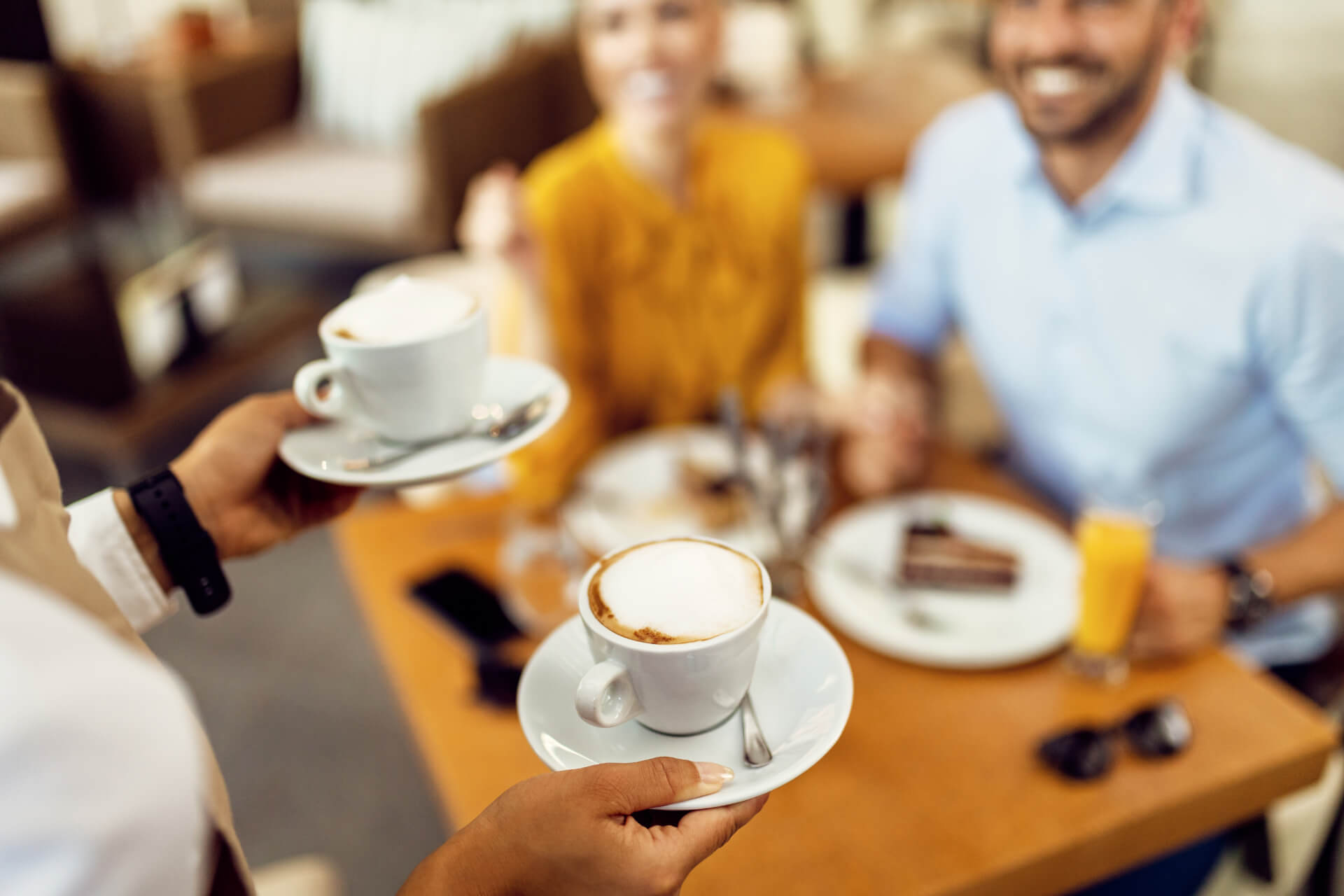 closeup-waitress-serving-coffee-couple-cafe